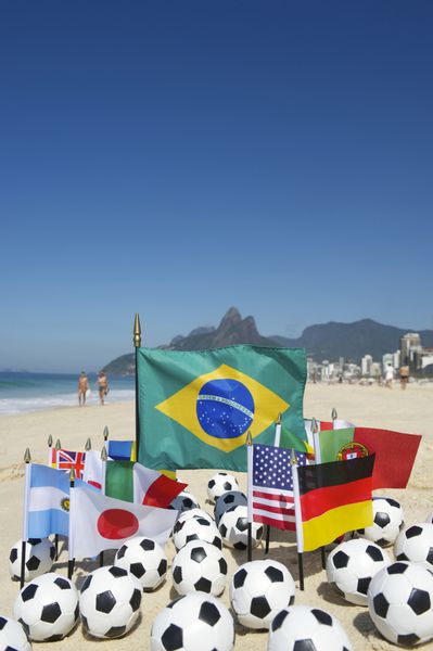 پرچم های تیم بین المللی فوتبال با توپ های فوتبال در ساحل ریودوژانیرو برزیل