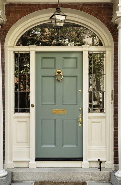 ورودی خانه با طراحی کلاسیک درب دارای یک کوبنده برنجی بزرگ و یک چارچوب زیبا است شات عمودی