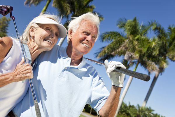 زن و شوهر سالخورده خوشبخت با هم گلف بازی می کنند و با هم لباس سبز می پوشند