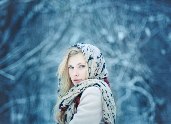یک زن بلوند جوان زیبا در جنگل زمستانی