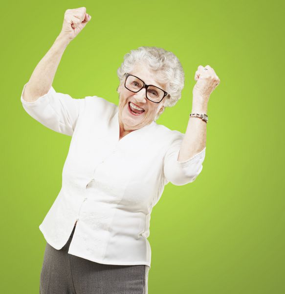 پرتره یک زن مسن شاد و با ژست پیروزی بر پس زمینه سبز