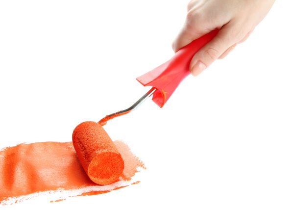 غلتک در دست با رنگ نارنجی جدا شده روی سفید