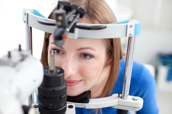زن جوان در حال معاینه چشم توسط چشم پزشک است