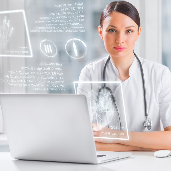 دکتر با صفحه نمایش کامپیوتر پیشرفته در حال مشاهده اطلاعات بیمار