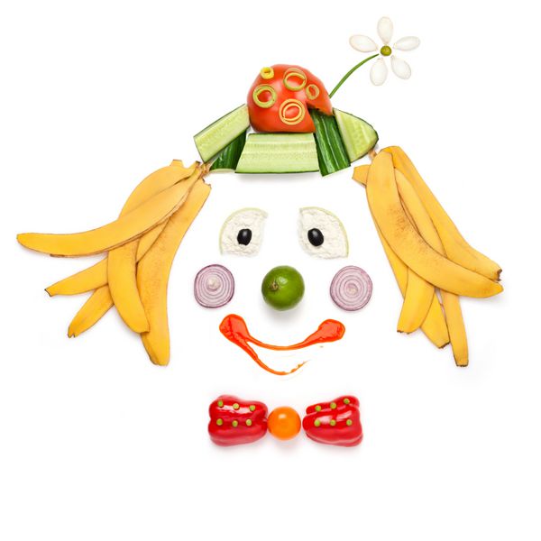 یک مفهوم غذایی خلاقانه که پرتره دلقک خندان ساخته شده از سبزیجات و میوه ها را در منوی کودکان نشان می دهد