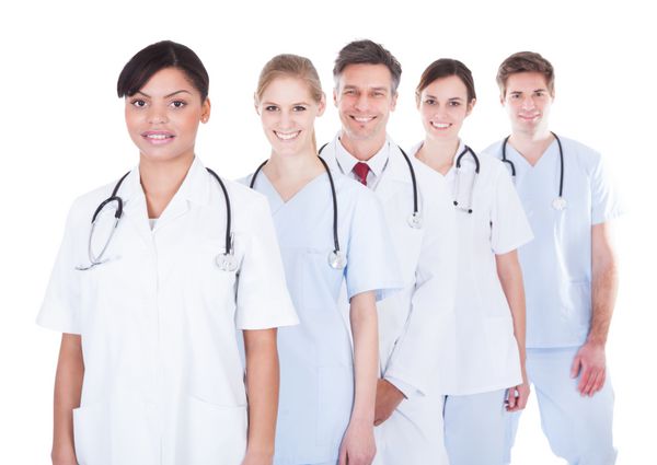 گروه شادی از پزشکان و پرستاران در یک ردیف بر روی زمینه سفید ایستاده اند