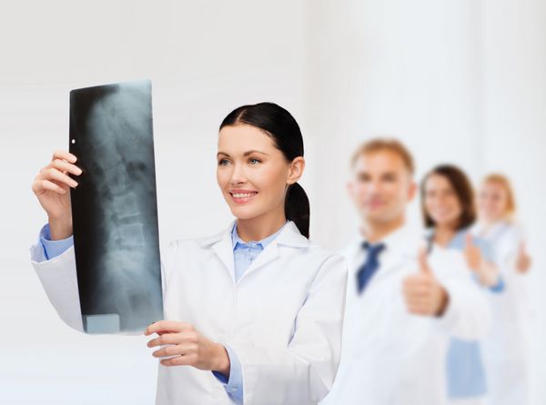 مفهوم مراقبت های بهداشتی پزشکی و رادیولوژی - دکتر زن خندان که به اشعه ایکس نگاه می کند
