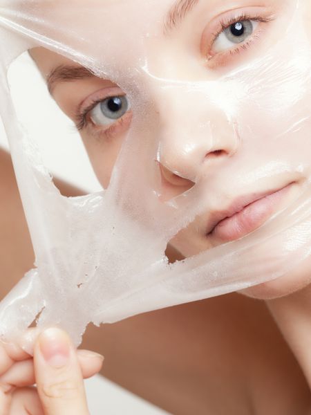 پرتره دختر جوان با ماسک لایه بردار صورت جدا شده روی سفید لایه برداری زیبایی و مراقبت از پوست بدن شات استودیویی
