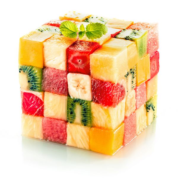 مکعب میوه از مربع‌های کوچک میوه‌های استوایی متنوع در آرایشی رنگارنگ از جمله کیوی توت فرنگی پرتقال موز و آناناس در زمینه سفید تشکیل شده است