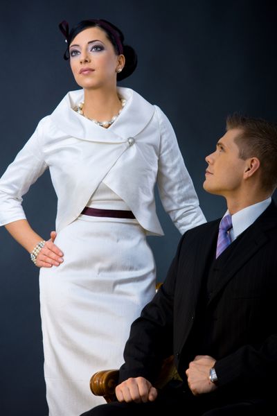 پرتره زوج جوانی که لباس های شیک پوشیده اند زن با پیراهن کوکتل سفید با ژاکت مردی با کت و شلوار سه تکه تیره