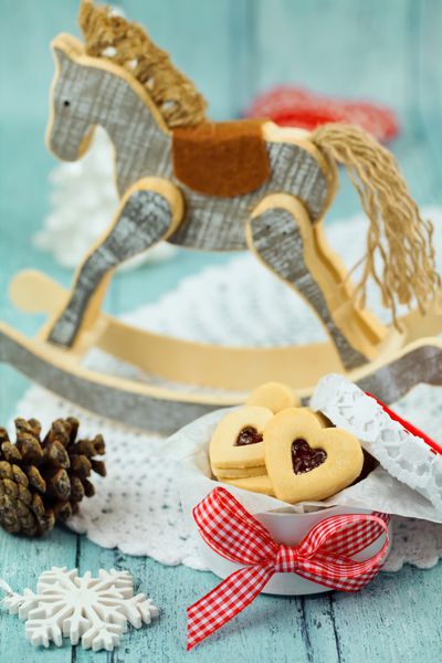 کوکی‌های ژله‌ای به شکل قلب کریسمس با اسب چوبی در پس‌زمینه به سبک وینتیج