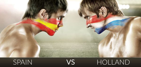 دو هوادار فوتبال با پرچم های رو در رو اسپانیا و هلند