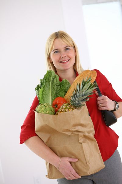 زنی که کیسه مواد غذایی در دست دارد