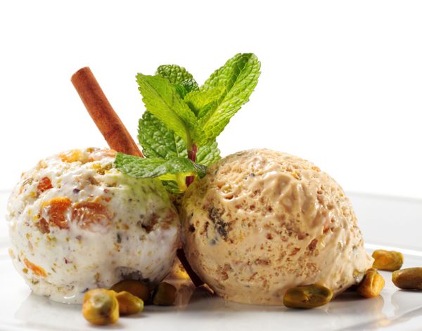 بستنی پسته با نعناع تازه و دارچین جدا شده بر روی پس زمینه سفید