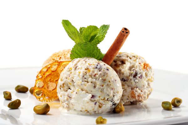 بستنی پسته با نعناع تازه و دارچین جدا شده بر روی پس زمینه سفید