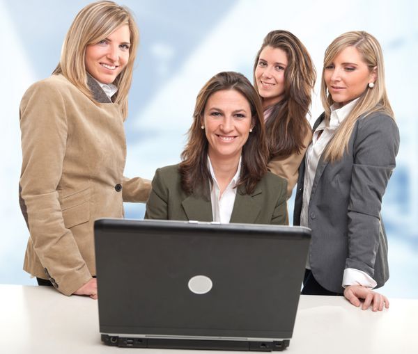 4 زن دور یک میز با کامپیوتر با چهره های شاد
