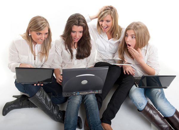 چهار دختر خندان روی زمین با رایانه و تبلت