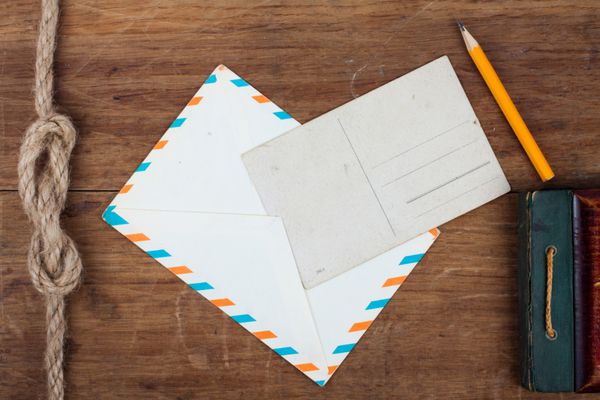 کاغذ قدیمی مداد پاکت نامه و کارت پستال در زمینه چوبی
