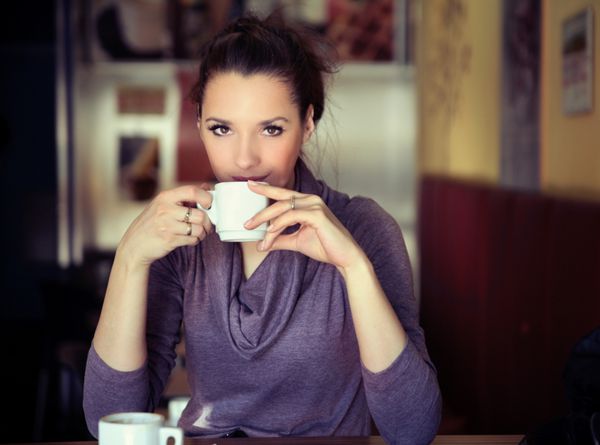 زن جوان در حال نوشیدن قهوه