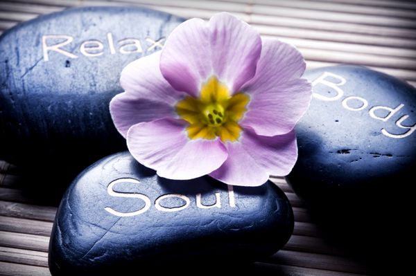 سه سنگ ماساژ - آرامش بدن روح - و یک گل مانند مفهومی برای سلامتی ریکی مراقبت از بدن و نمادهای یوگا