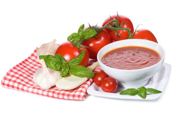سوپ گوجه فرنگی با برگ ریحان و سبزیجات در پس زمینه سفید