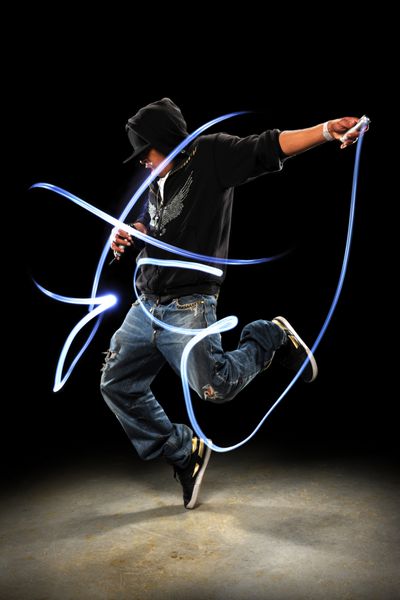 رقصنده هیپ هاپ در حال اجرا با چراغ‌های LED که روی پس‌زمینه تیره با نورافکن می‌رقصند