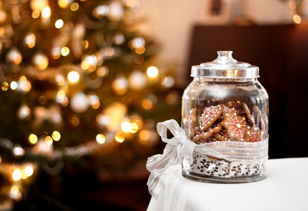بیسکویت شیرینی زنجبیلی خانگی در ظرف شیشه ای پس زمینه کریسمس