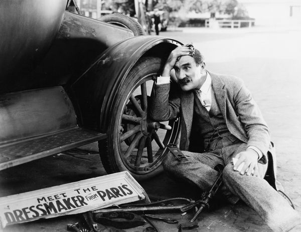 مردی که تلاش می کند ماشین شکسته را تعمیر کند