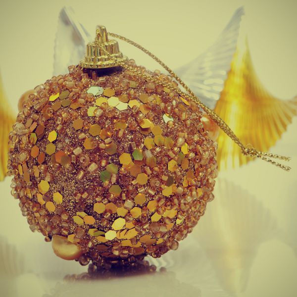 یک توپ طلایی کریسمس و یک حلقه گل طلایی و نقره ای با جلوه رترو