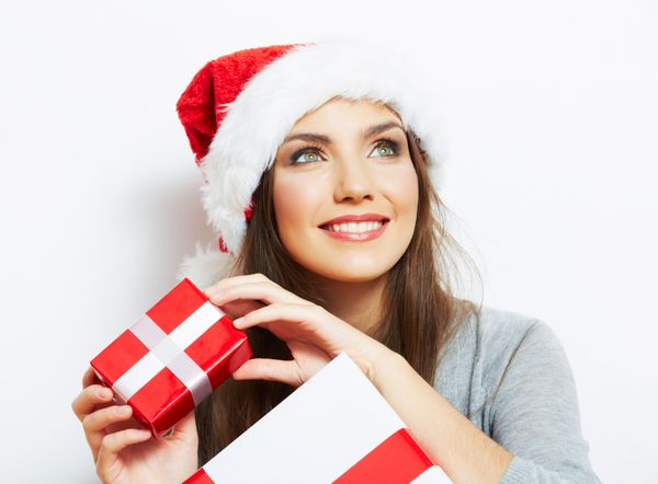 هدیه کریسمس نگهدارنده پرتره زن با کلاه بابانوئل کریسمس دختر شاد خندان در پس زمینه سفید