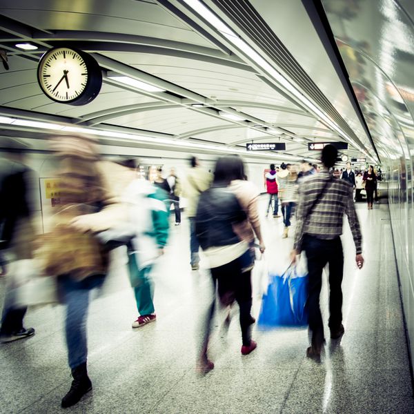 افراد تجاری در ایستگاه مترو تاری انتزاعی راه می روند