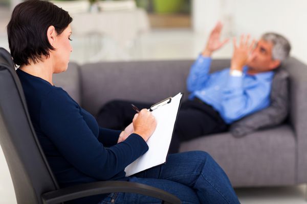 روانشناس زن میانسال هنگام صحبت کردن بیمار یادداشت می کند