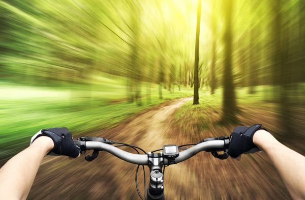 دوچرخه‌سواری کوهستانی در پایین تپه در حال پایین آمدن سریع با دوچرخه نمایی از چشم دوچرخه سواران
