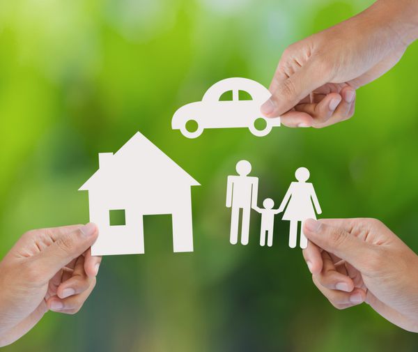 دست در دست گرفتن خانه کاغذی ماشین خانواده در پس زمینه سبز مفهوم بیمه
