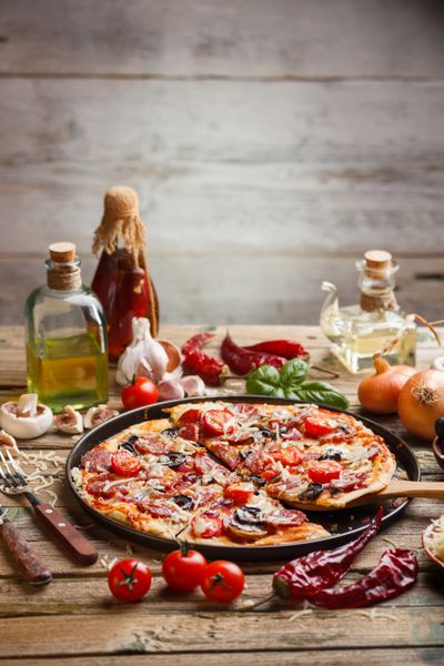 پیتزای تهیه شده با سالامی موزارلا قارچ زیتون و سس گوجه فرنگی
