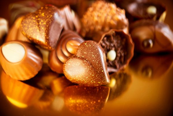 شکلات های ولنتاین انواع آب نبات شکلاتی شیرینی شکلاتی طراحی حاشیه آب نبات روی پس زمینه طلایی شکلات قلبی شکل