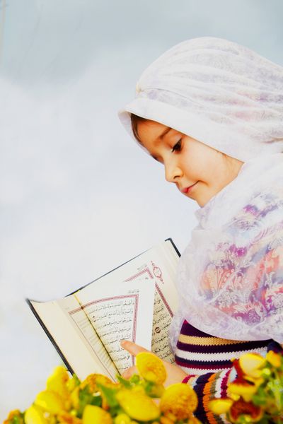 دختر مسلمانی که قرآن کتاب مقدس را در دست دارد