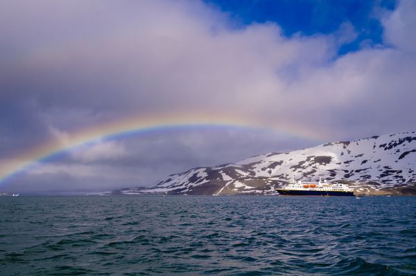 هورنسوند اسوالبارد نروژ - 26 ژوئیه 2010 کشتی کروز اکسپلورر نشنال جئوگرافیک در مقابل یک یخچال طبیعی در اقیانوس منجمد شمالی