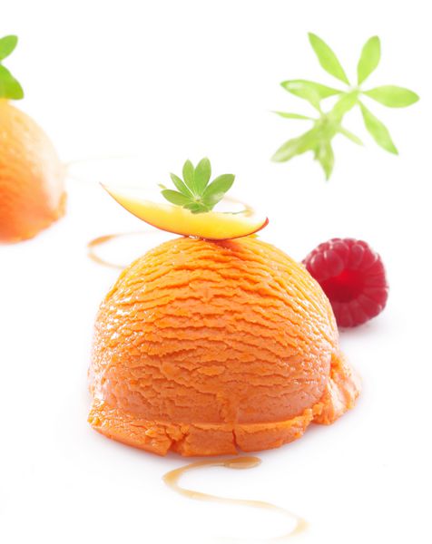 تک پیمانه دسر بستنی انبه استوایی پرتقالی رنگارنگ در زمینه سفید