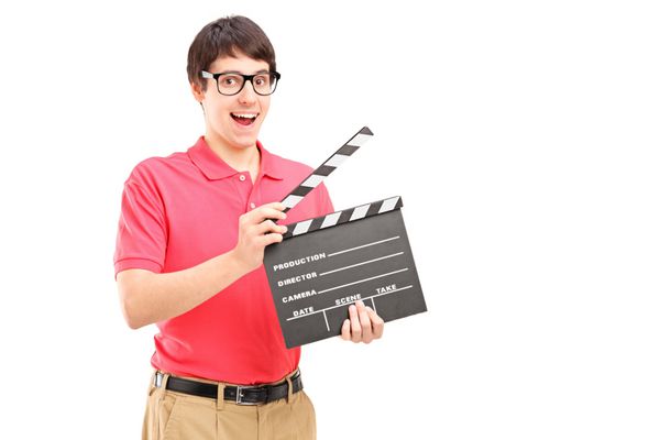 مردی خندان با عینک که یک فیلم سینمایی جدا شده روی پس‌زمینه سفید در دست دارد