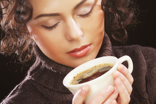 زن زیبا در حال نوشیدن قهوه