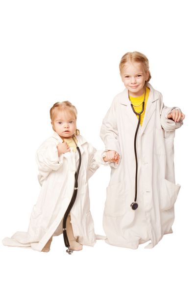 دو خواهر به عنوان پزشک بازی می کنند دخترانی که روپوش پزشکی و فونندوسکوپ به تن دارند جدا شده در زمینه سفید
