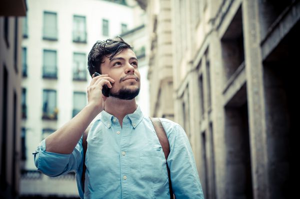 مرد شیک در خیابان در تلفن در شهر