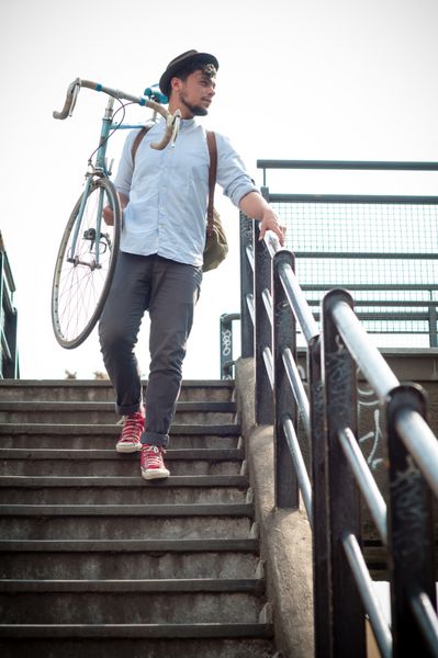 مرد جوان هیپستر با دوچرخه در شهر