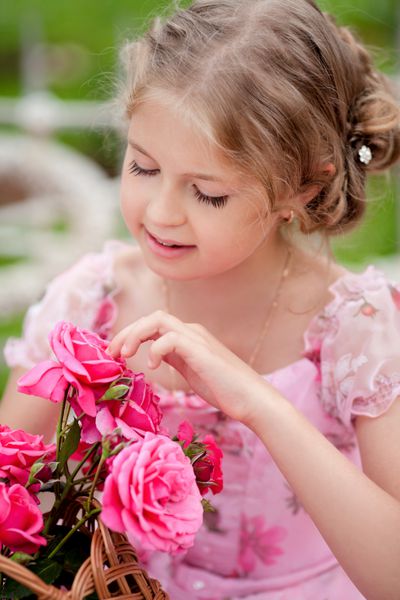 پرتره دختر کوچک زیبا با گل های رز