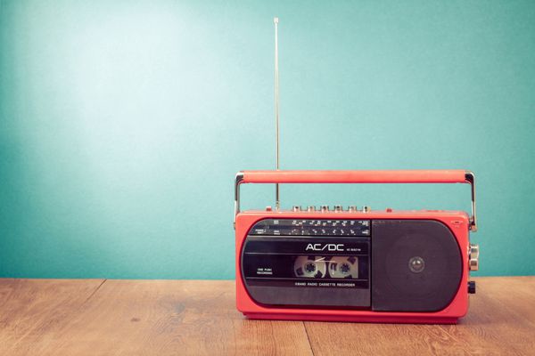 ضبط کاست رادیویی قدیمی رترو قرمز روی میز در پس زمینه سبز نعنایی جلو
