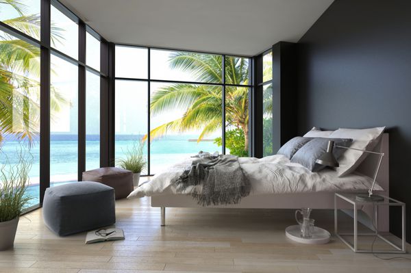 فضای داخلی اتاق خواب استوایی با تخت دو نفره و منظره دریا