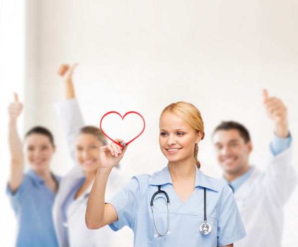 مراقبت های بهداشتی پزشکی و فناوری - دکتر یا پرستار جوان که قلب قرمز را ترسیم می کند