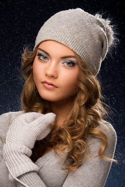 دختری با لباس زمستانی در هنگام بارش برف
