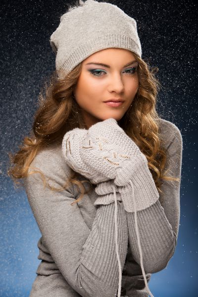 دختری با لباس زمستانی در هنگام بارش برف